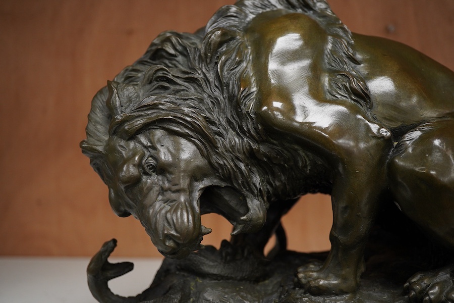 A patinated bronze group of a lion and snake, J.B Paris foundry stamp, signed Coreira, on a black marble base, 23cm high